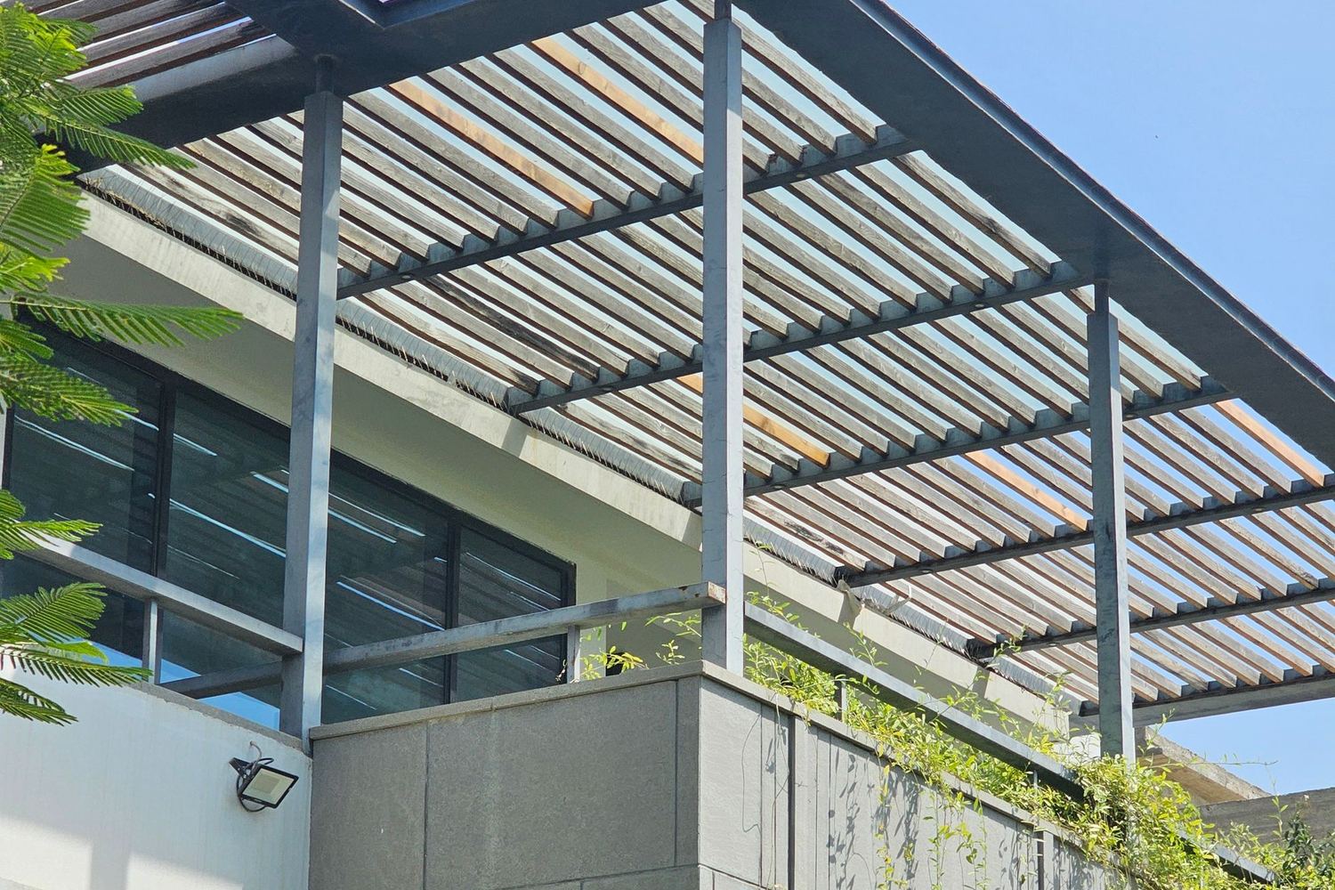 Pérgola de aluminio con lamas sobre una terraza con muebles de exterior