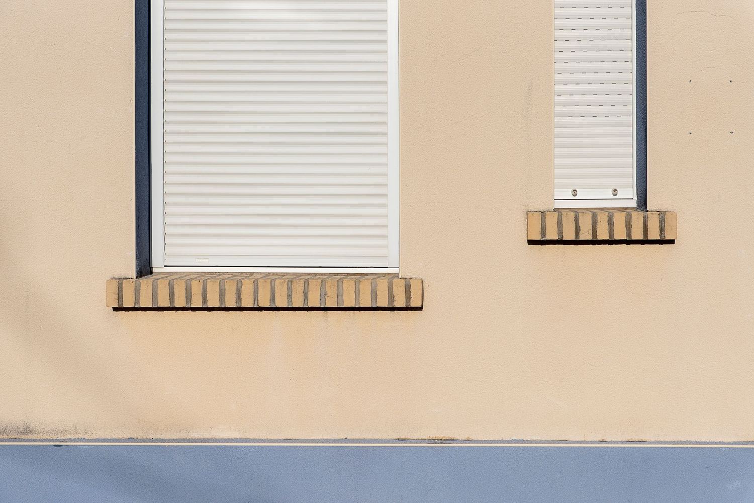 Ventanas con persianas enrollables de lamas en una fachada